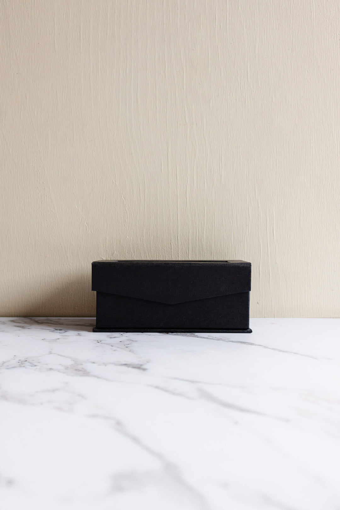 A vintage Rosenthal crystal votive sits on a white marble surface against a plain beige wall, its presence evoking refined elegance.