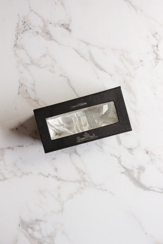 A black rectangular box with a clear window showcases a vintage Rosenthal crystal votive inside, resting on white marble. The box is labeled Crystal Critter and Resem Blest, reflecting Rosenthal's signature elegance.