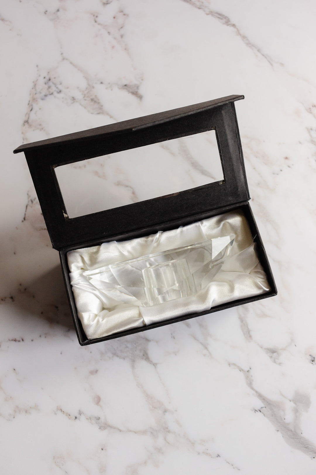 A vintage Rosenthal crystal votive in a black box lined with white satin, displayed on a light marble surface. The open box lid features a clear window for viewing, echoing the luxury style of Rosenthal porcelain.
