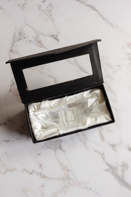 A vintage Rosenthal crystal votive in a black box lined with white satin, displayed on a light marble surface. The open box lid features a clear window for viewing, echoing the luxury style of Rosenthal porcelain.