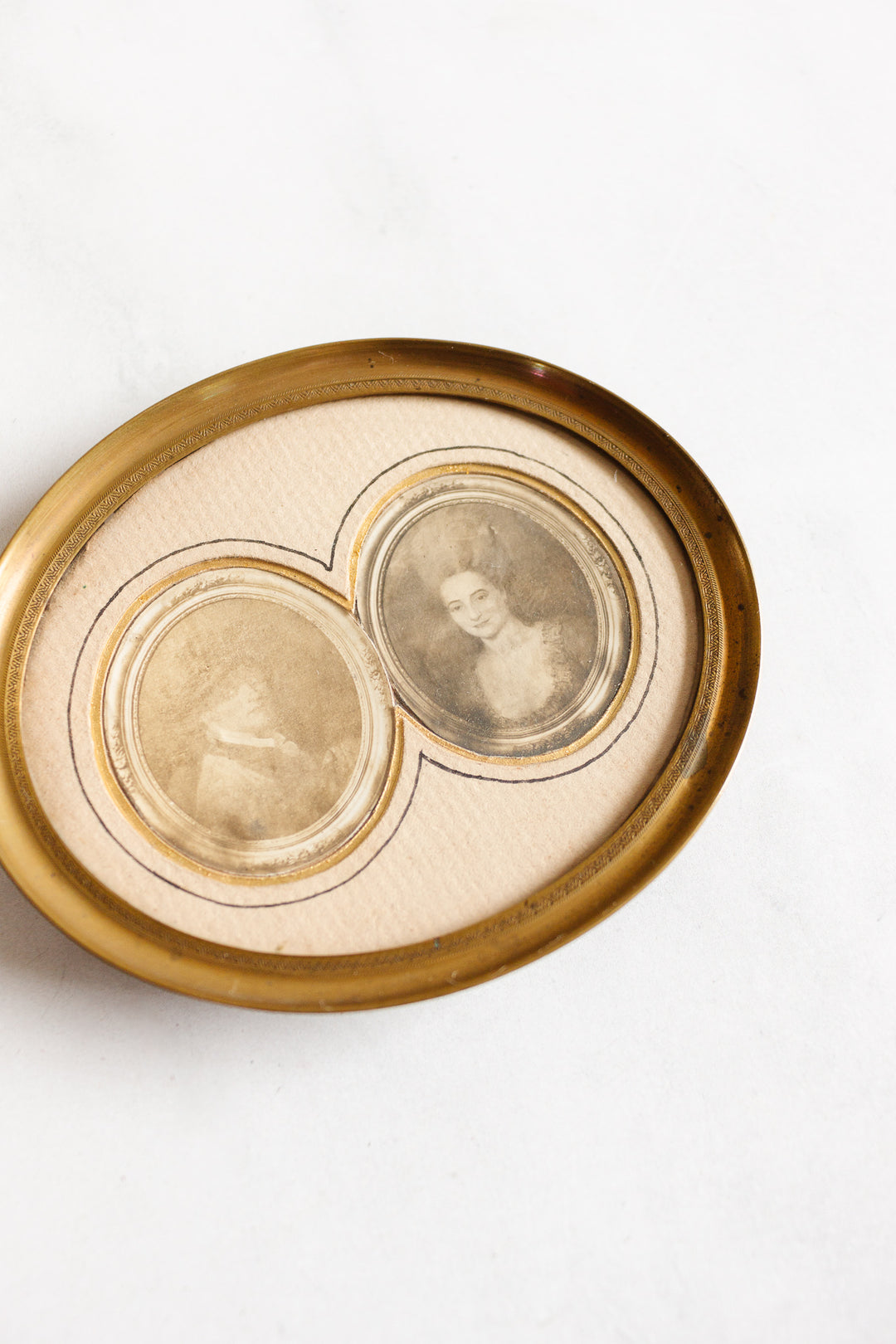 A 1920s French petite double portrait frame with French matting displays two sepia-toned vintage portraits of women side by side on cream, one clear in period attire, the other softly fading into history.