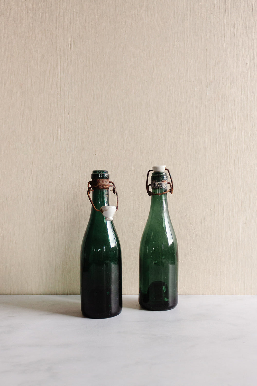 pair of vintage french green glass porcelain top bistro bottles