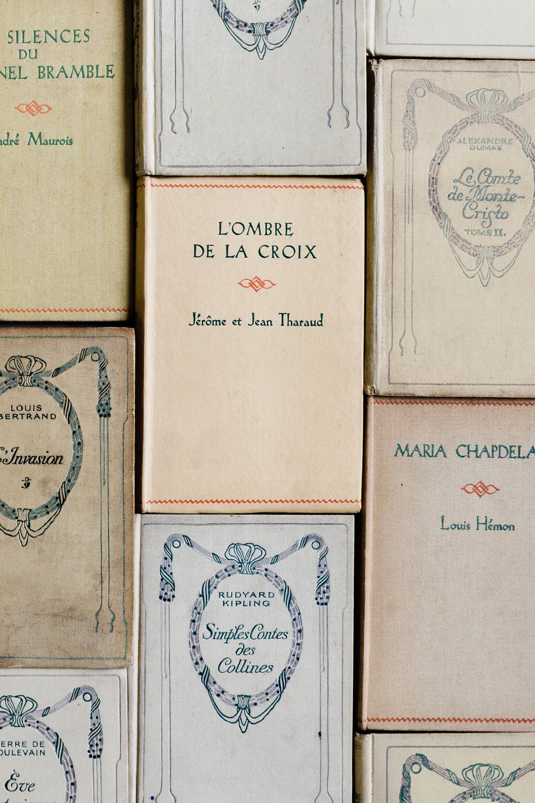 A curated set of vintage French books, including "L'Ombre de la Croix" by Jérôme et Jean Tharaud and "Maria Chapdelaine" by Louis Hémon, features decorative covers, varied sizes, and timeless charm.