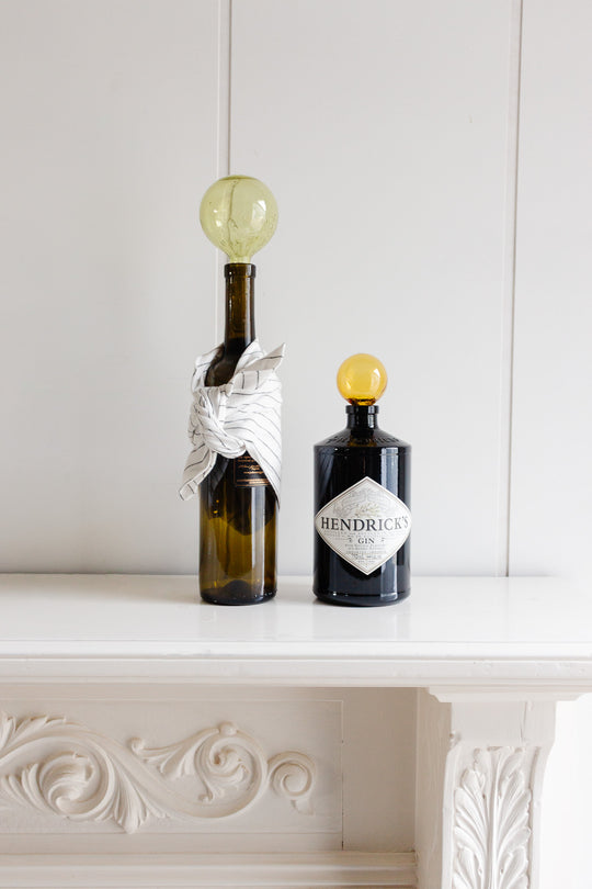 Two vintage French blown glass "courge" bottles on a shelf evoke rustic elegance, perfect for adding a touch of Provence decor to any space.