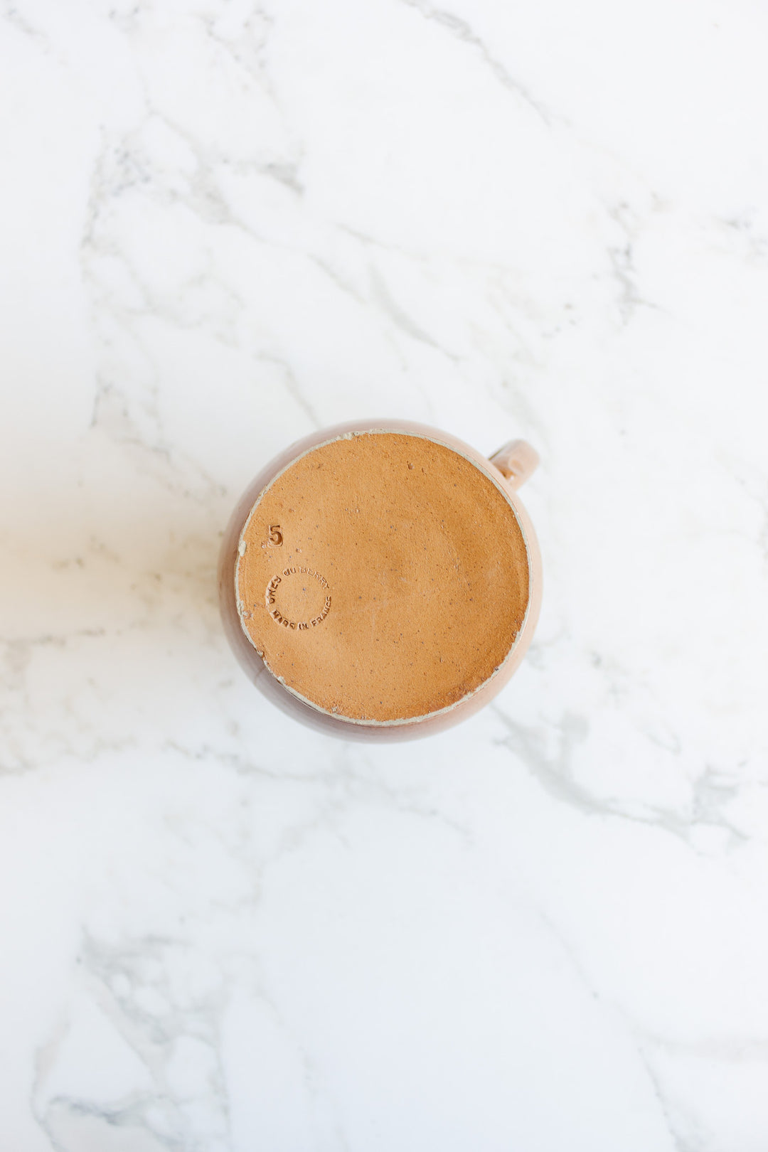A large jug sits on a white marble surface, viewed from above, emphasizing its elegant dimensions.