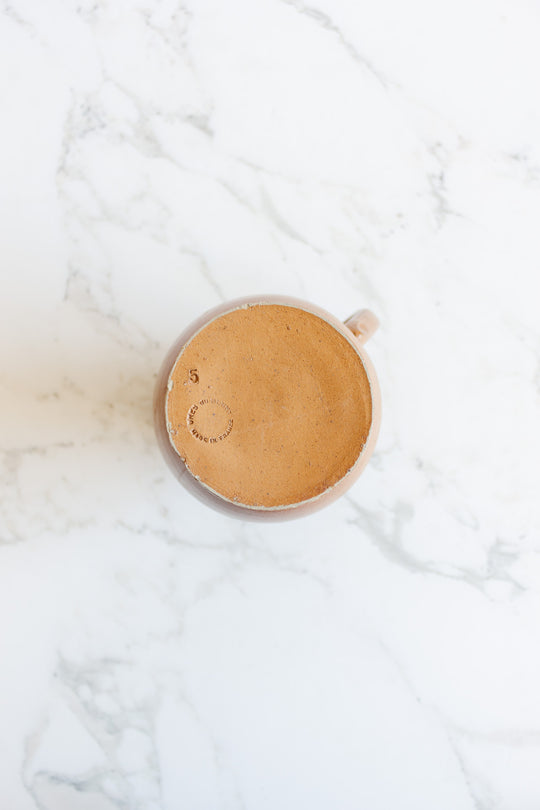 A large jug sits on a white marble surface, viewed from above, emphasizing its elegant dimensions.