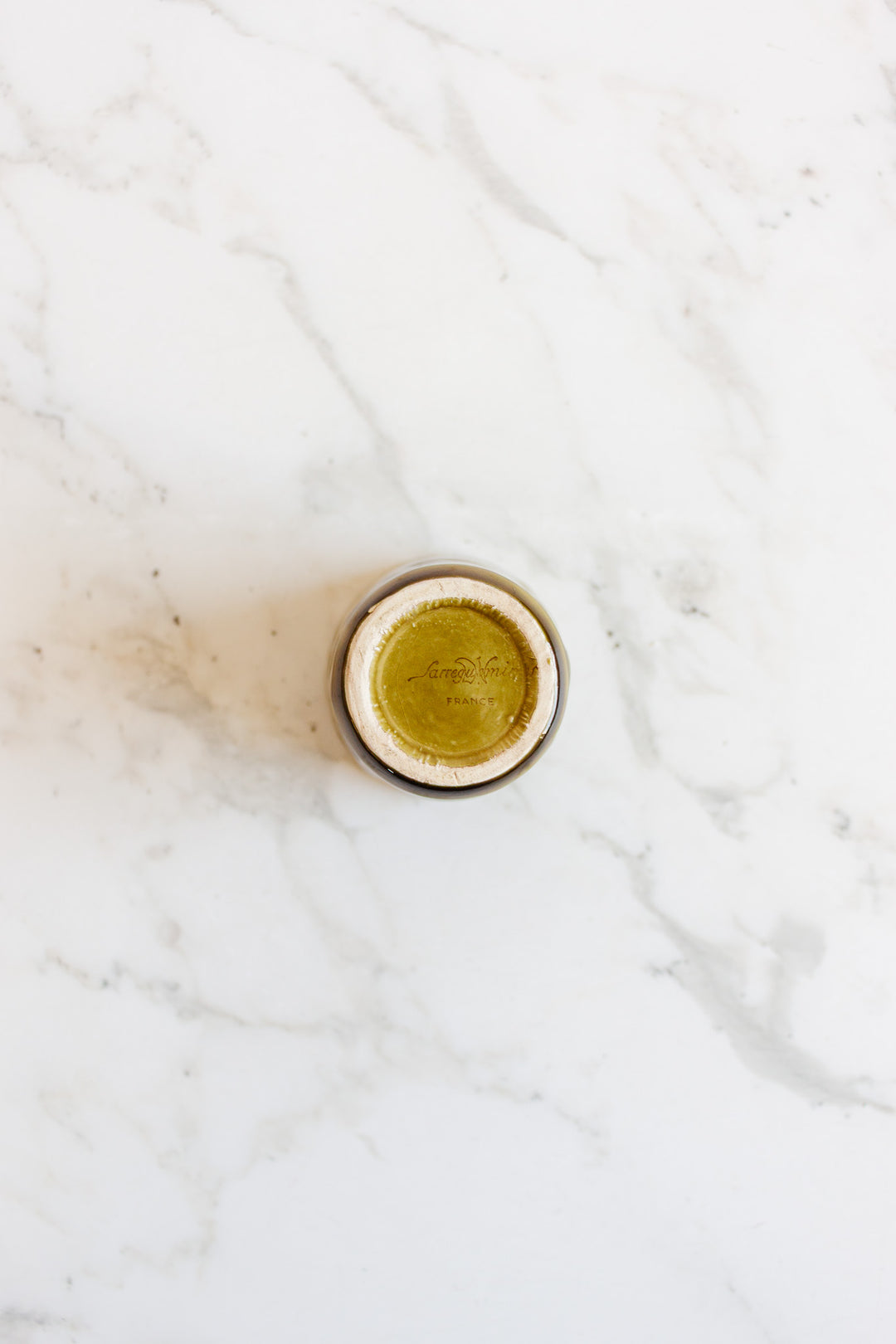 A compact drinkware set filled with greenish-yellow liquid is seen from above on a white marble surface, showcasing its vibrant color and sleek design.