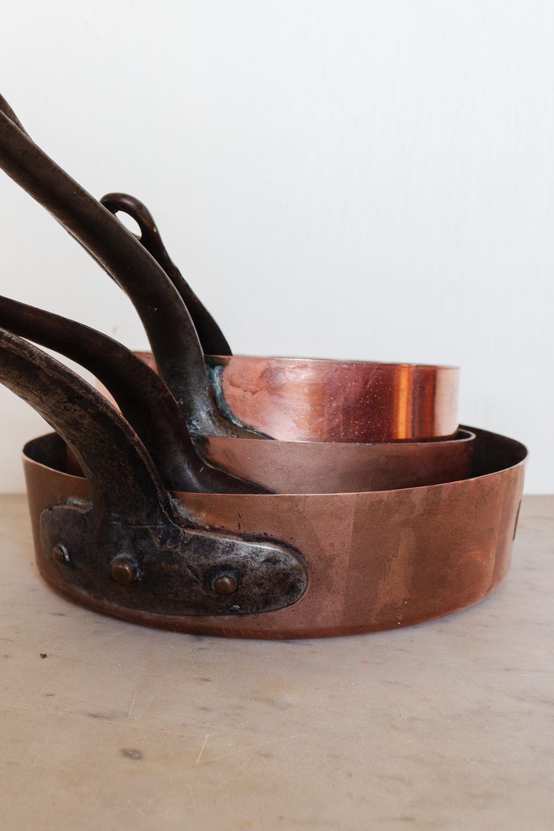 Antique French stamped copper pans, graduated set of 3