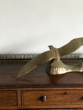 vintage brass bird at sea